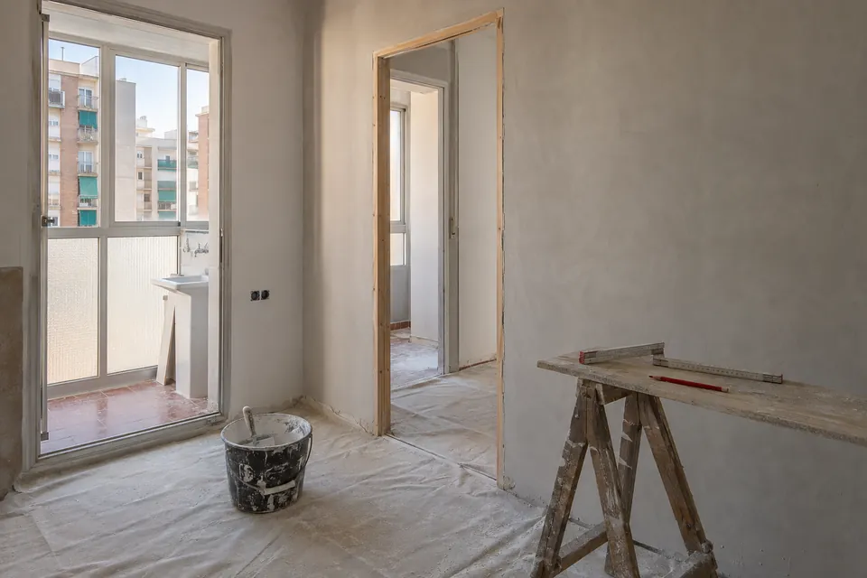 Tabique nuevo enlucido con marco de puerta en un piso al final de la obra