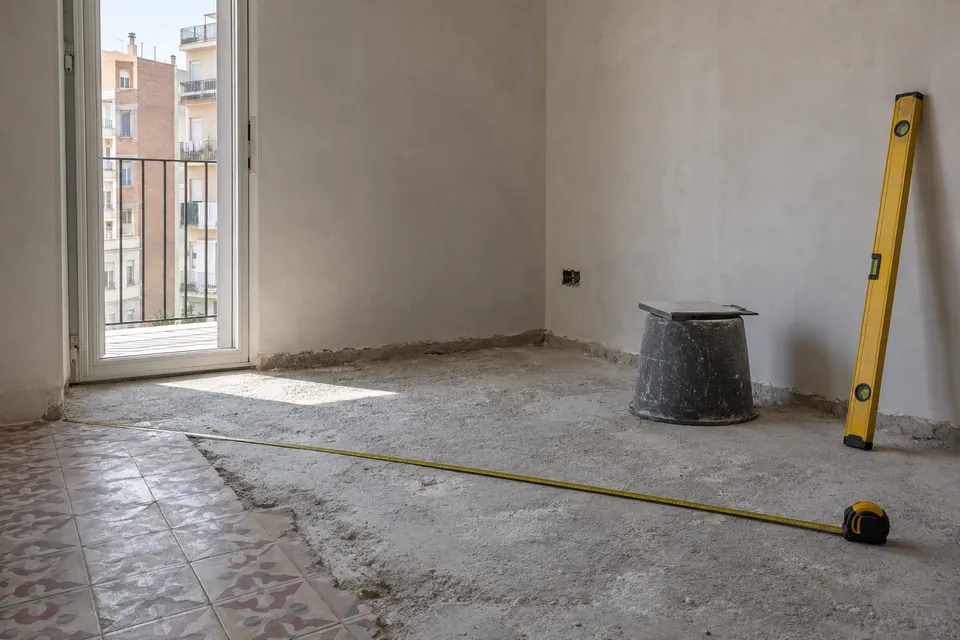 Cinta métrica sobre el suelo de un piso pequeño vacío antes de calcular el precio de la reforma